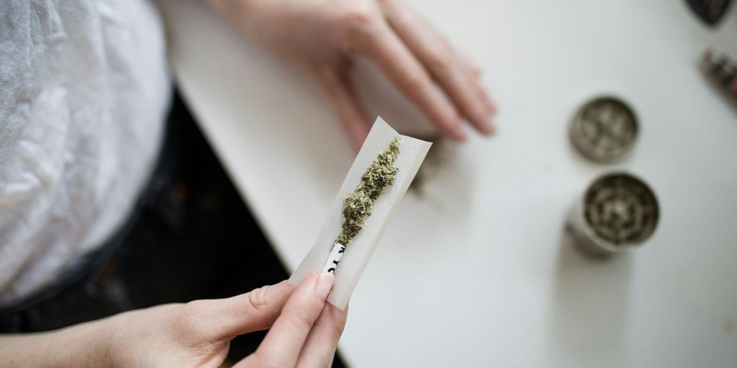 Person dreht eine Cannabiszigarette